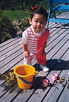 Thea playing with cups and water at home in Norway.